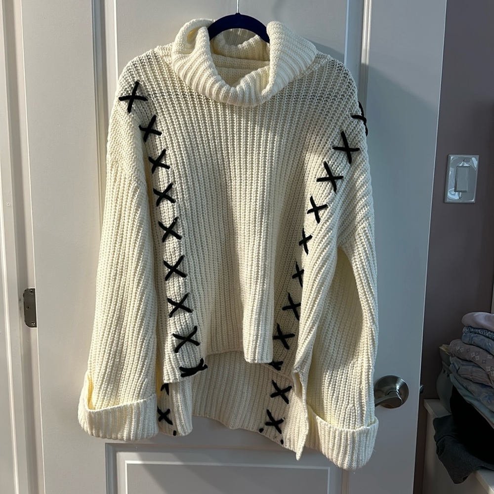 Beautiful cream, heavy sweater with black details on each side, cow neck